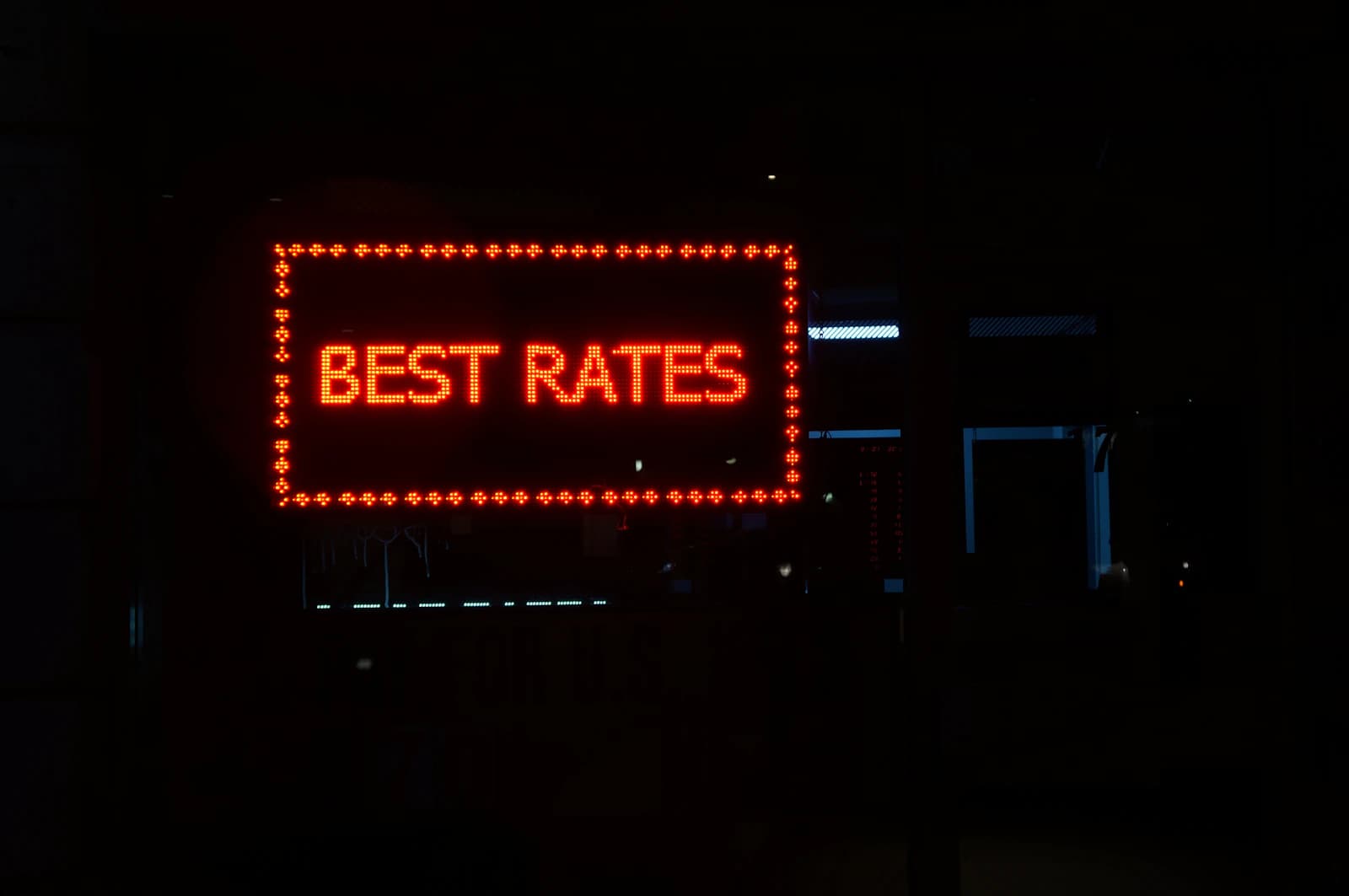 A glowing red 'BEST RATES' LED sign lit up at night